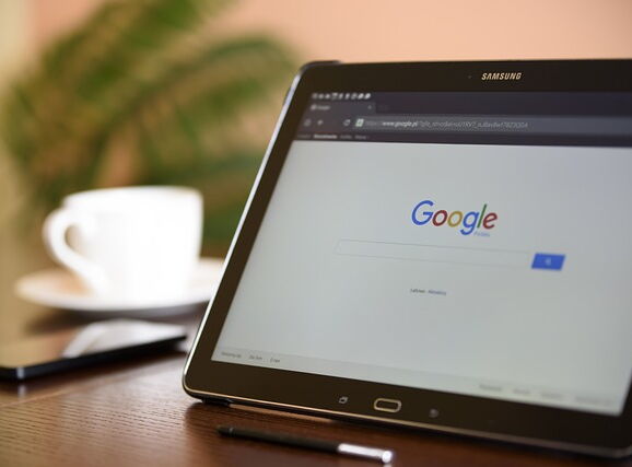 Mobiler Arbeitsplatz mit Tablet, Smartphone und Kaffee.