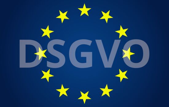 Zeichen der Europäischen Union. Schriftzug DSGVO blass hinter den Sternen abgesetzt.