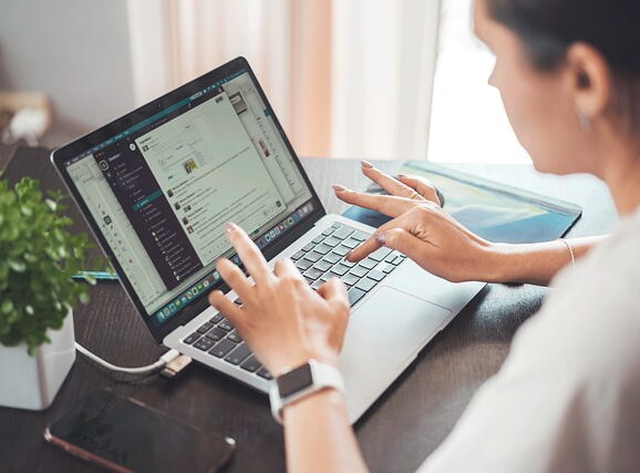 Eine Frau aktualisiert ihre Website am Laptop.