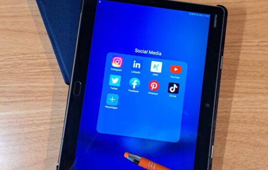 Buchkalender 2023, Kugelschreiber mit der Aufschrift HZ WebDesign, Tablet auf dem verschiedene Social Media Apps zusehen sind.