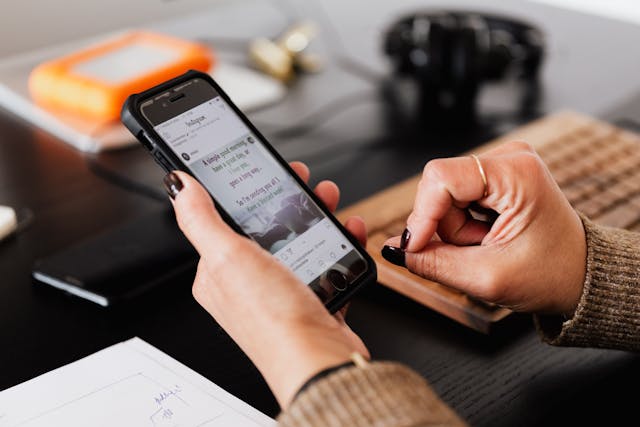 Eine Frau schaut sich auf ihrem Smarthphone verschiedene Social Media Kanäle an.